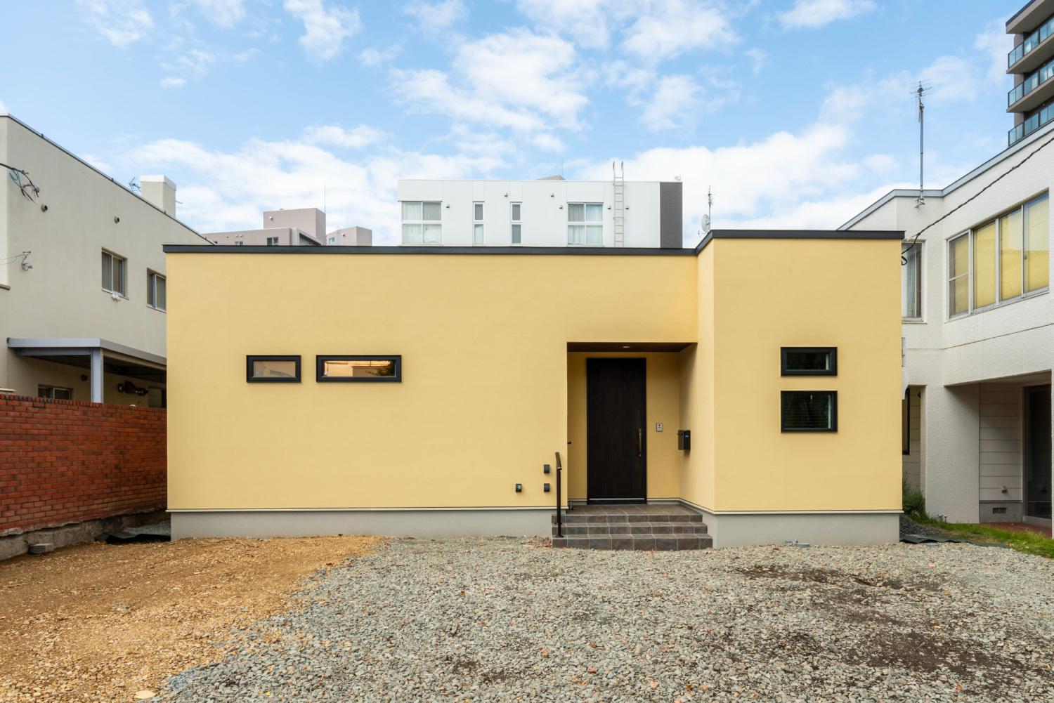 やさしいイエローカラーの外観でかわいらしい印象の平屋