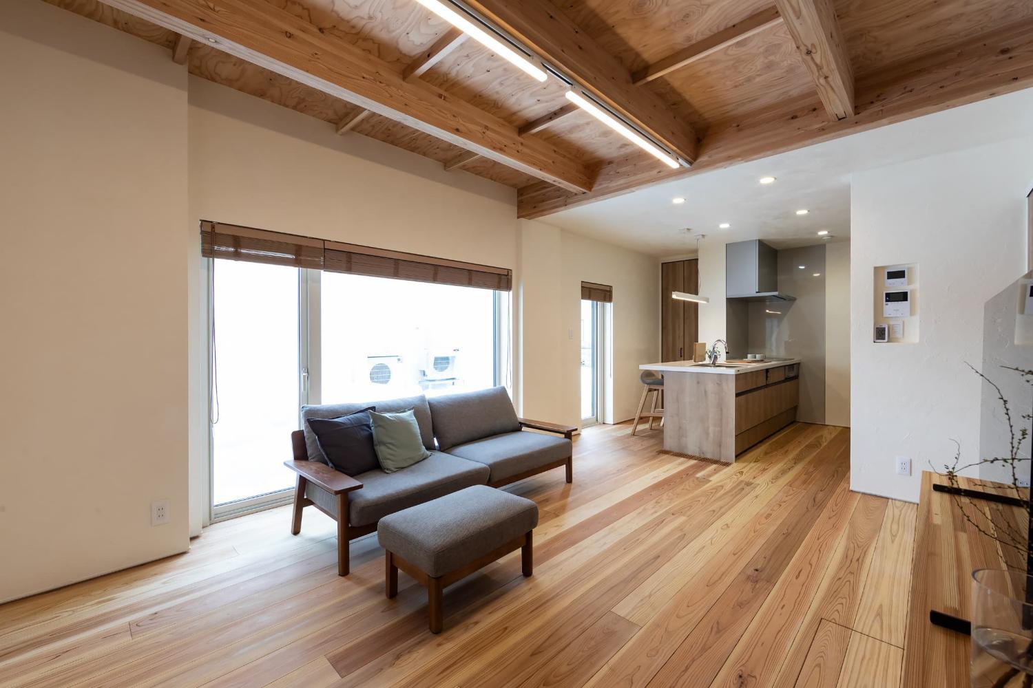 床の無垢材ともリンクする天井梁で木の表情が豊かなリビング