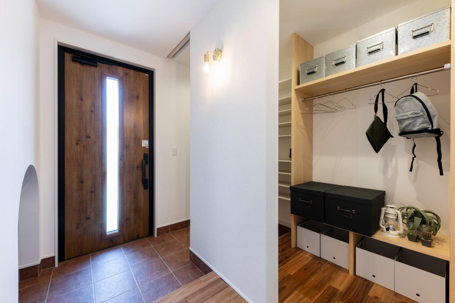 外出時に使う靴やコート、帽子を見せる収納としてまとめられるおしゃれな玄関ホール