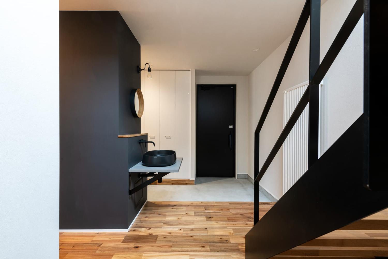 濃い色のアクセントクロスを差し込んだ個性的でおしゃれな玄関ホール