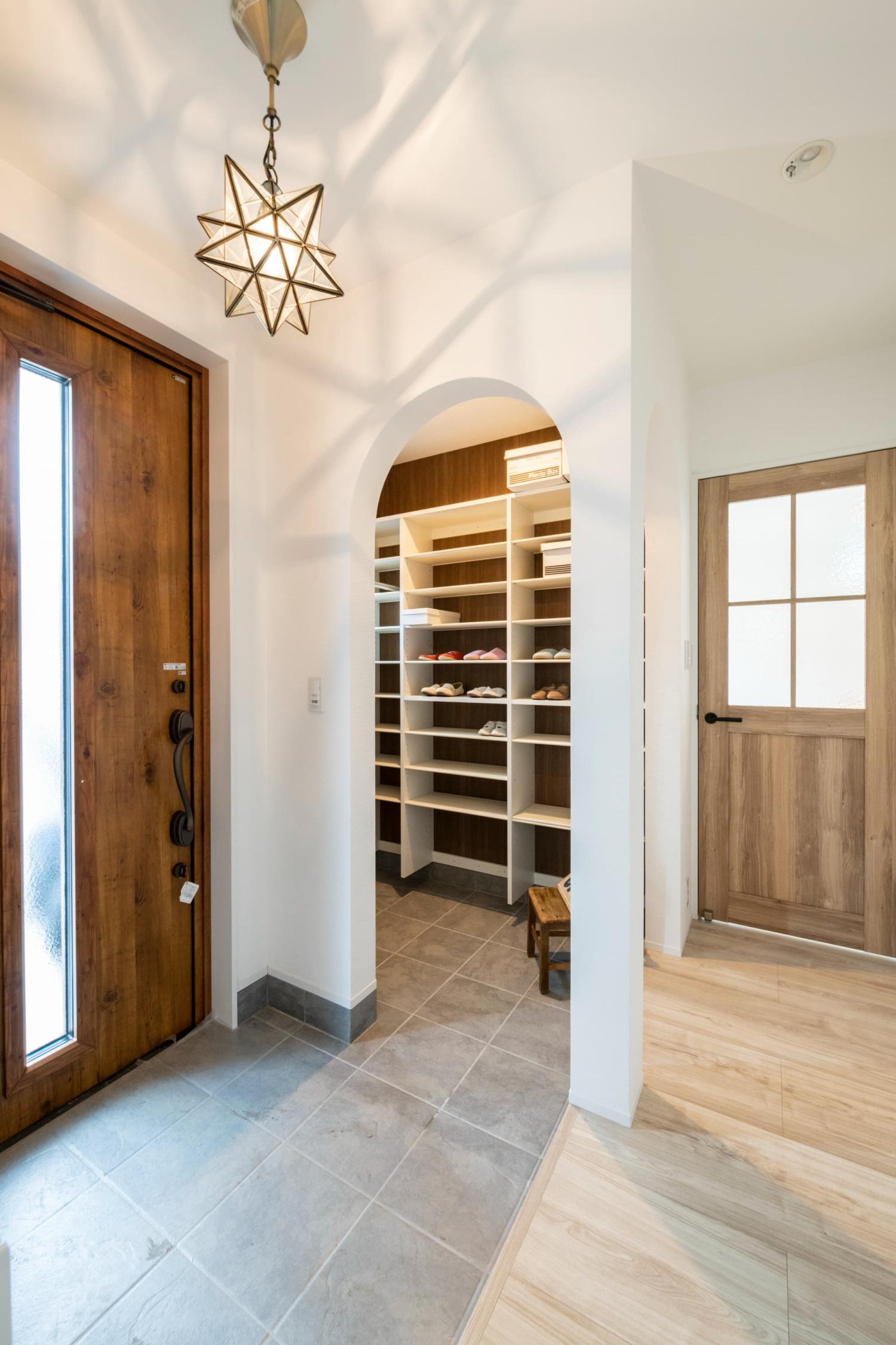 個性的な照明が陰影を生み出すナチュラルテイストの玄関ホール