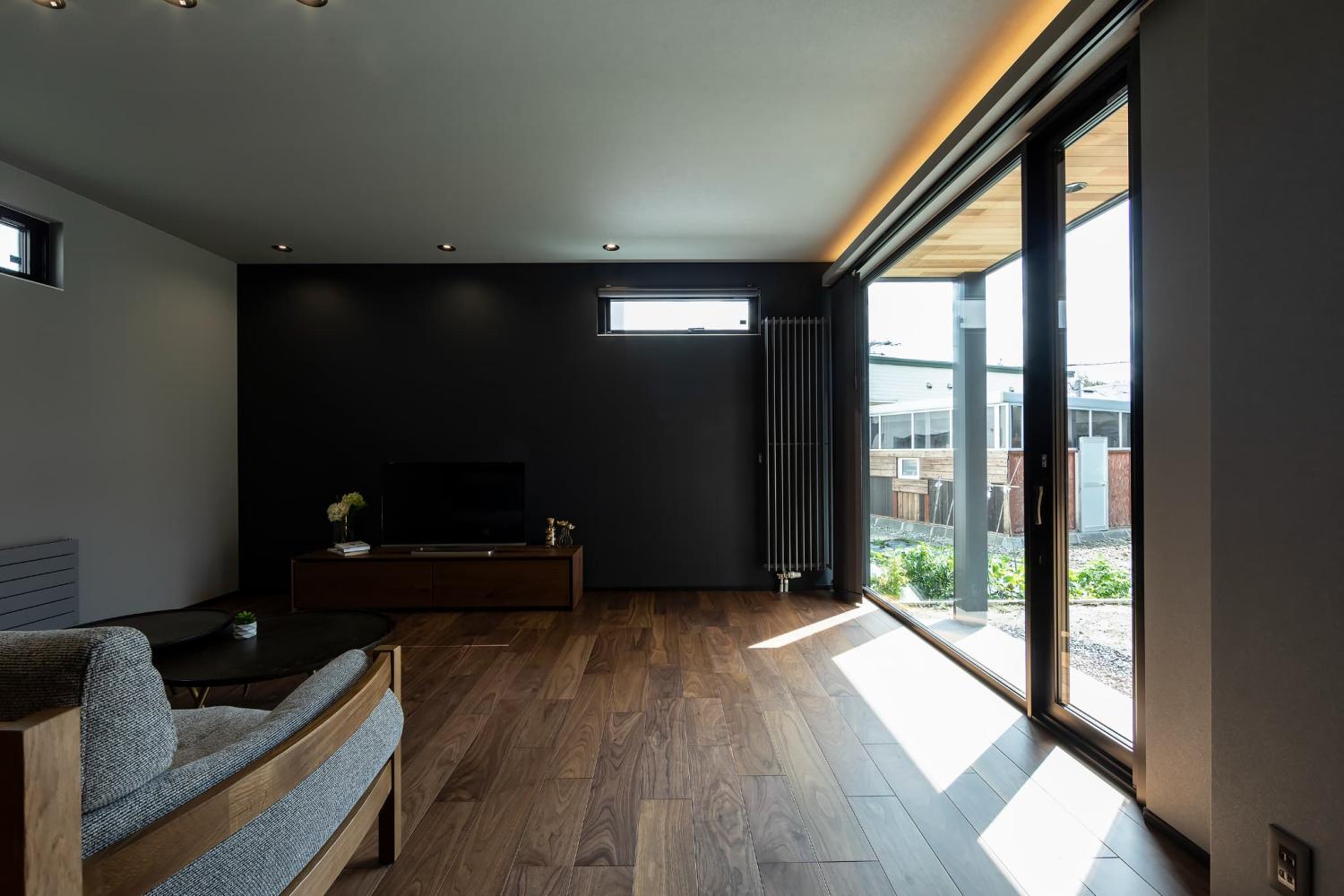 無地のダークグレーをアクセントクロスに採用したリビング