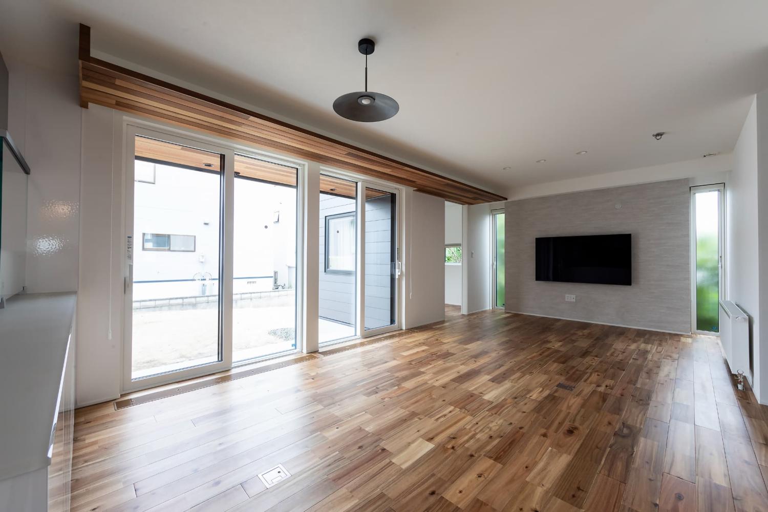 テレビ背面に淡いグレートーンのアクセントクロスを採用したリビング