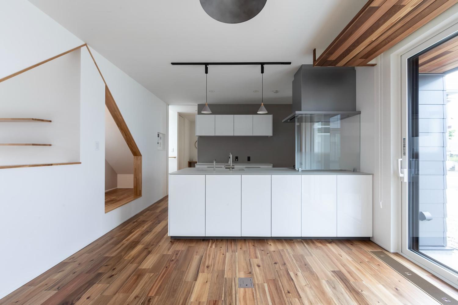 キッチンの背面やヌックの奥にグレーのアクセントクロスを採用したLDK