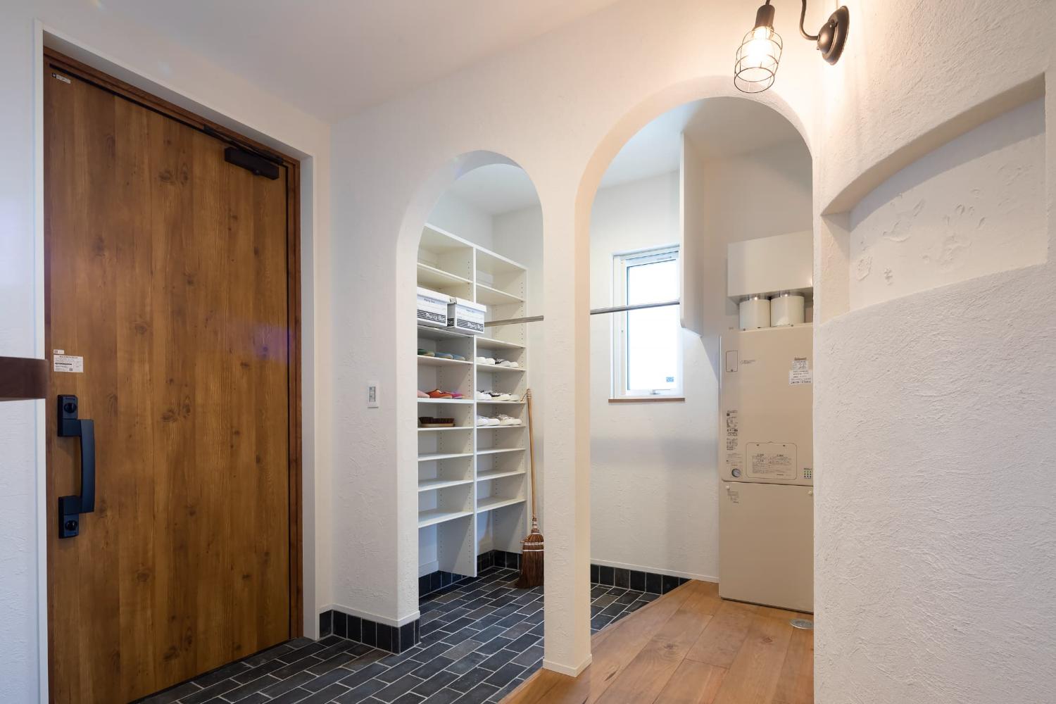 R垂れ壁や個性的な照明がアクセントのおしゃれな玄関ホール