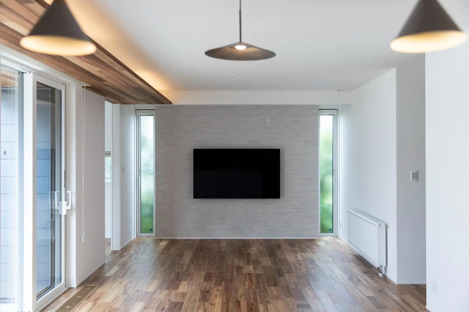 石目調グレーのアクセントクロスが映えるシンプルなリビング空間