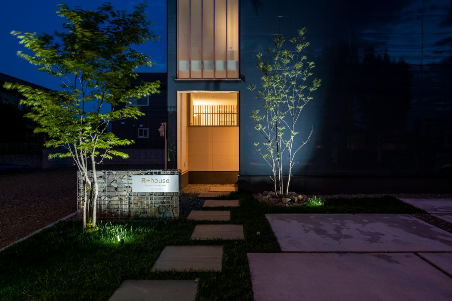 樹木を下から柔らかく照らす照明によって、夜もぬくもりを感じられる玄関外構