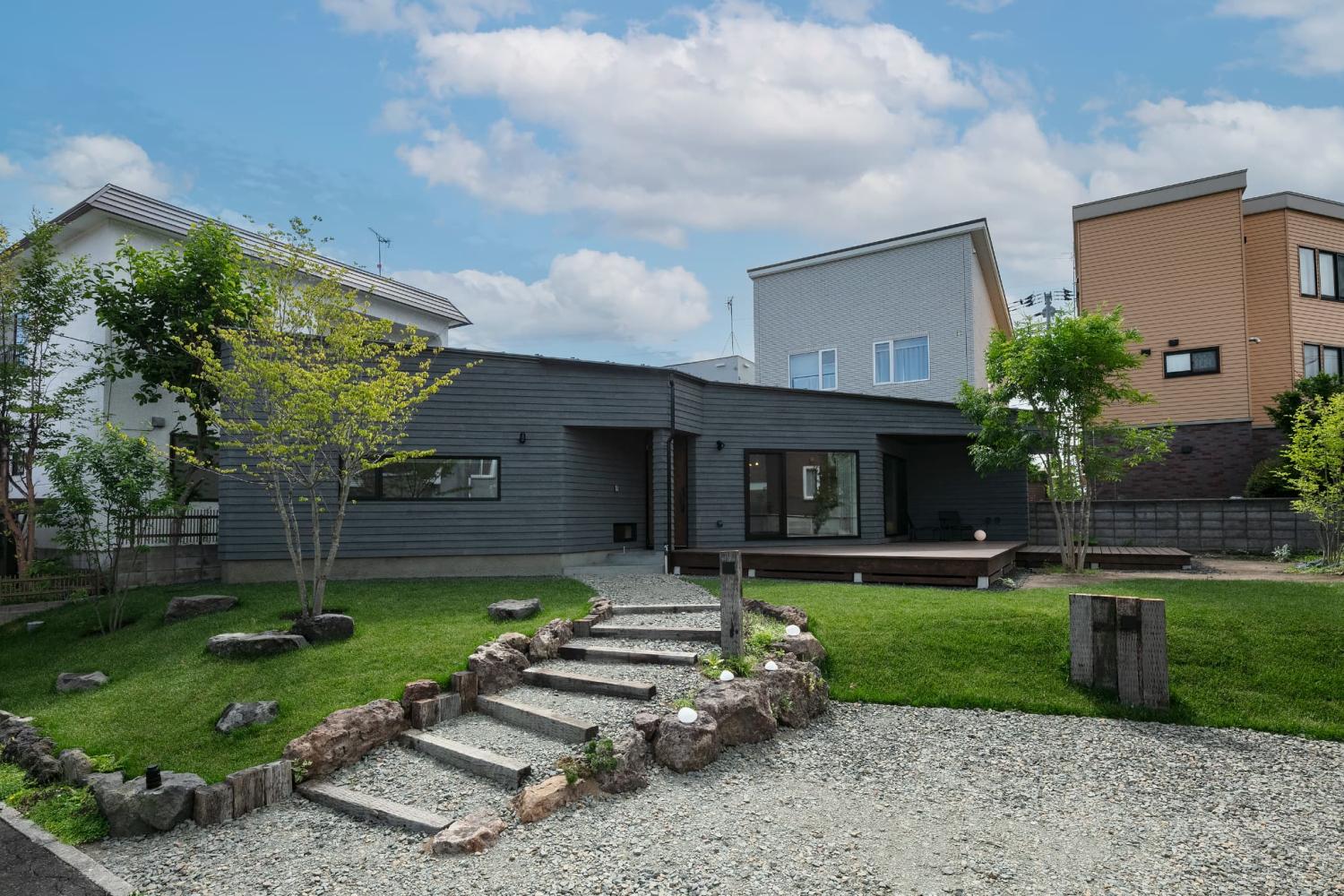 砂利や枕木、天然の岩石など、自然素材をふんだんに使った緑あふれる外構