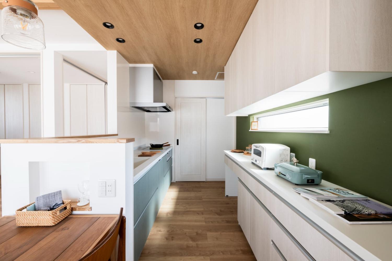 木天井とグリーン壁が映えるⅡ型のキッチンレイアウト